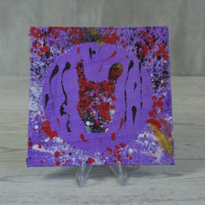 Original 5x5 inch square abstract painting on canvas panel featuring a central textured red and black rock-on hand symbol inside a light purple circle, surrounded by chaotic crimson red and black paint splatters on a purple background, displayed on a clear stand.