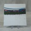 20260914_132629 Original 5x5 inch square abstract painting on canvas panel featuring a horizontal stripe of turquoise blue, magenta pink, and textured dark green paint across a white background with subtle dark paint splatters, shown on a clear plastic stand.