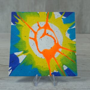 20260914_132904 Original 5x5 inch square abstract spin painting on canvas panel featuring organic branching neon orange streaks over a central metallic silver circle, surrounded by a bright yellow and lime green burst with deep blue corners, displayed on a clear stand.